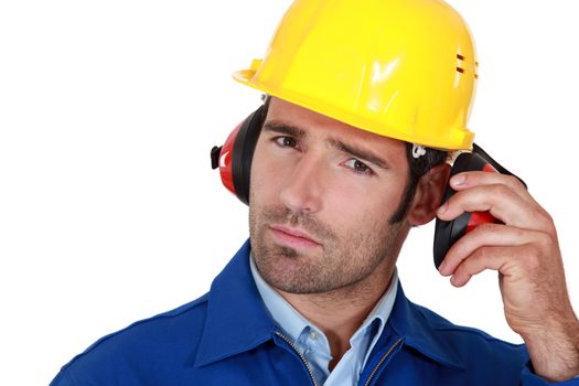 Man wearing safety earmuffs and helmet