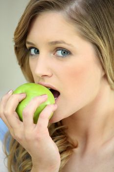 Girl eating a crisp green apple