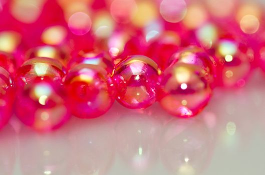 Red beads on white surface with mirror image