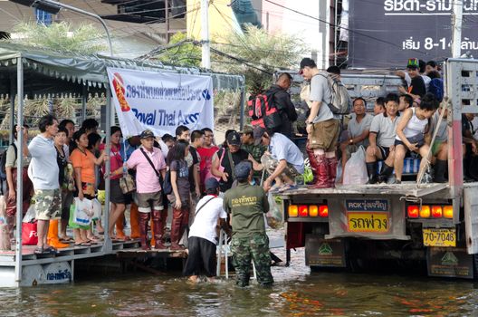 BANGKOK THAILAND – NOVEMBER 13: Truck carries a group of people to evacuate from the flooded area at Phahon Yothin Road during the massive flood crisis on November 13, 2011 in Bangkok, Thailand.