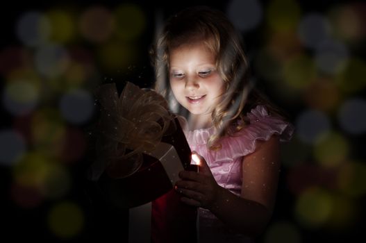 girl opens a box with a gift, beams therefrom shine and magic opens