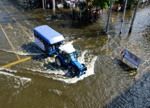 BANGKOK THAILAND – NOVEMBER 13: Truck carries a group of people to evacuate from the flooded area at Phahon Yothin Road during the massive flood crisis on November 13, 2011 in Bangkok, Thailand.