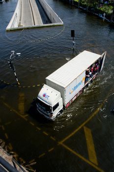 BANGKOK THAILAND – NOVEMBER 13: Truck carries a group of people to evacuate from the flooded area at Phahon Yothin Road during the massive flood crisis on November 13, 2011 in Bangkok, Thailand.