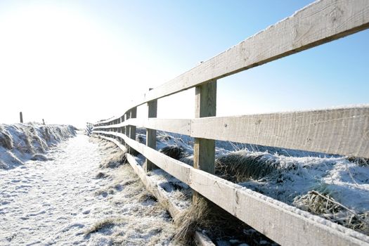 frosty winters view at ballybunion cliffside walk with bright sun and fence