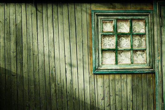 Wooden wall of green color, with a square window Vintage
