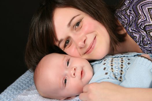 Beautiful brunette mother with her baby boy dressed in blue