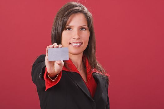 Young brunette offering a credit card-selective focus on her face.Shot with Canon 70-200mm f/2.8L IS USM