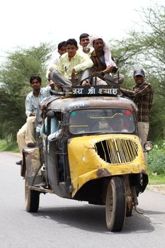 crazy road scene in India - small car with people