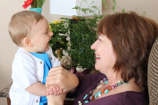 Beautiful baby boy sitting by his grandmother