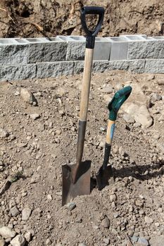 An adult and child sized spade next to one another