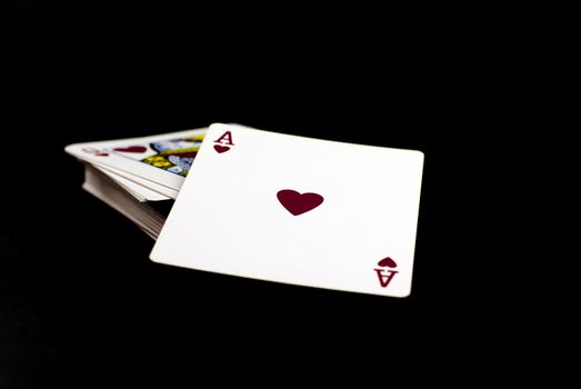 
a pack of playing cards with the ace of hearts to top;black background