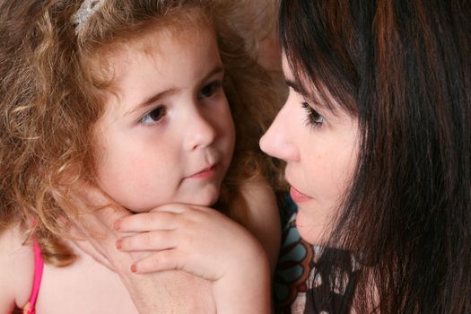 Beautiful mother and daughter against a brick wall background