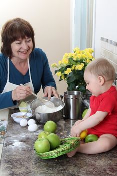 Grandmother and grandson in the kitchen baking cake 