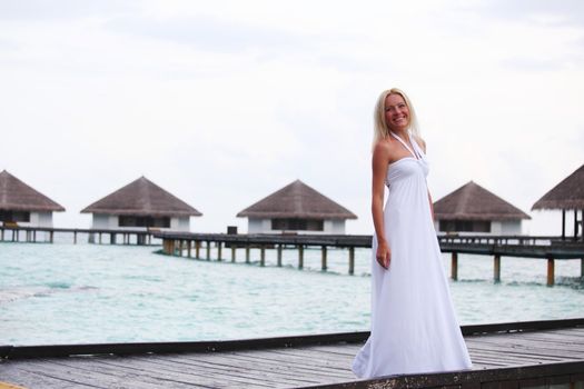 woman in a dress on a bridge home sea