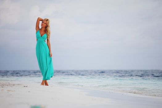 woman in a blue dress on the ocean coast