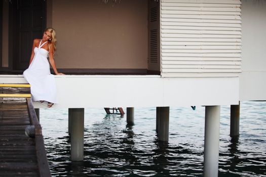 woman in a dress on a bridge home sea