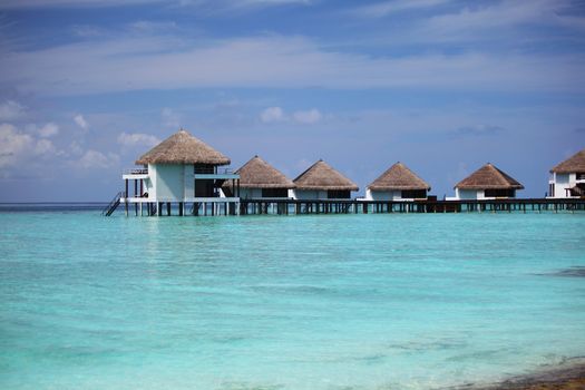 resort maldivian houses in blue sea