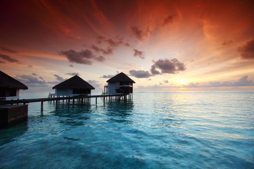 resort maldivian houses on sunrise