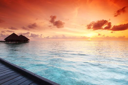 resort maldivian houses on sunrise