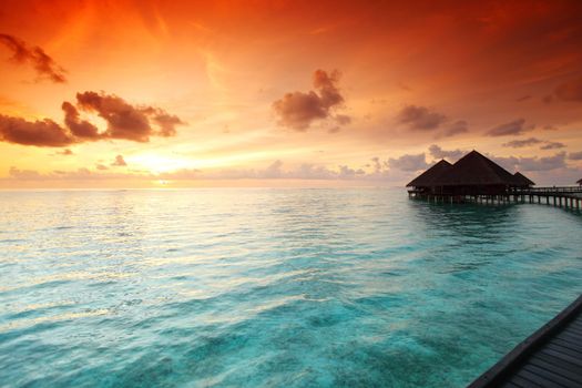 resort maldivian houses on sunrise