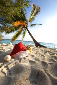 santa hat on sand under palm