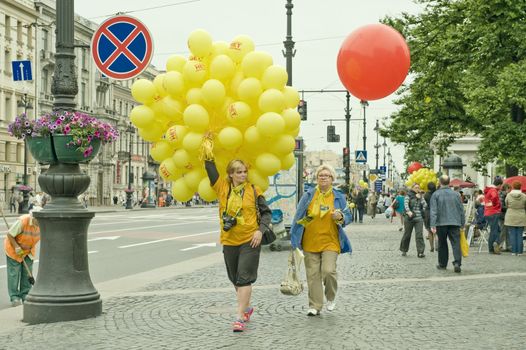 Two woman with yellow and re balloons, taken in St Petersburg, Russia.