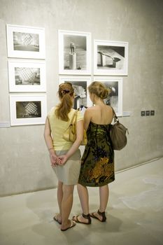 Two woman on photo exhibition taken in Moscow, Russia