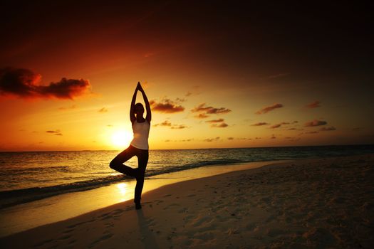 sunset yoga woman on sea coast