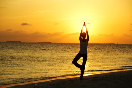 sunset yoga woman on sea coast