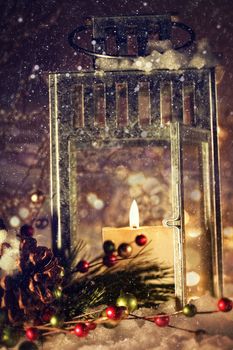 Brightly lit lantern with candle in the snow