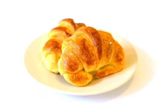  two fresh croissant ,casting soft whadow on white. 