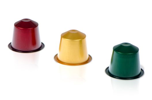 Coffee capsules for a coffee machine, close up view on white reflective background.