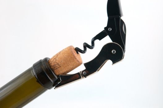 Dark brown bottle with a cork and corkscrew which is screwed into the cork