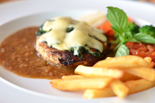 Grilled chicken steak served with chips, potatoes and vegetables