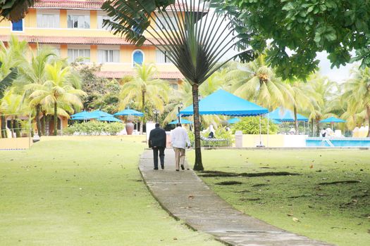 View of two gangster males talking in a backyard of a mansion