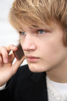 Teenage boy using mobile phone outdoors, close-up