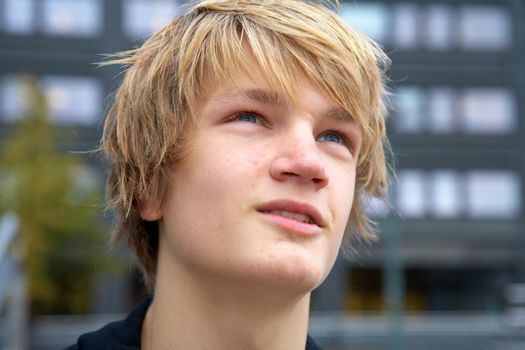 Portrait of hopeful teenage boy outdoor in city, close-up
