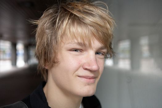 Teenage boy smiling in city street, looking at camera