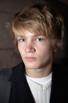 Portrait of teenage boy before building wall, looking at camera