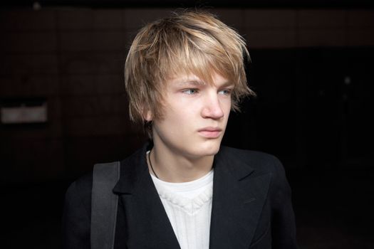 Portrait of teenage boy in street, looking away