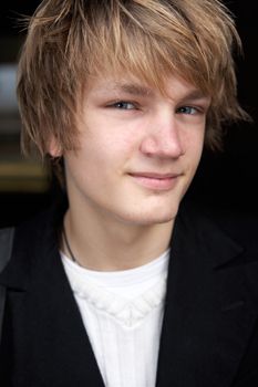 Close-up of teenage boy in street, smiling