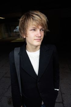 Portrait of happy teenage boy in street, looking away