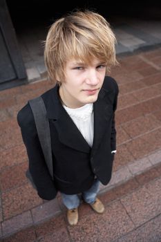 High angle view of teenage boy standing in street, looking at camera