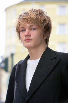 Portrait of teenage boy in street, low angle view
