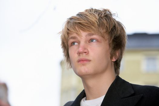 Portrait of teenage boy in street, contemplating