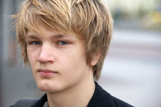 Portrait of teenage boy in street, cropped close-up