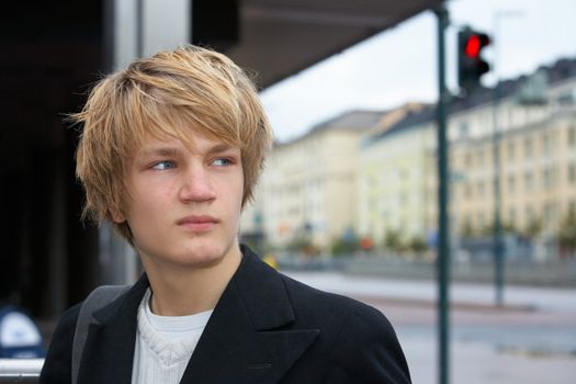 Teenage boy in street, traffic light in background