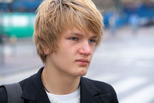 Teenage boy in street, looking away, close-up