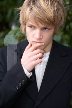 Teenage boy contemplating in city park, frontal view