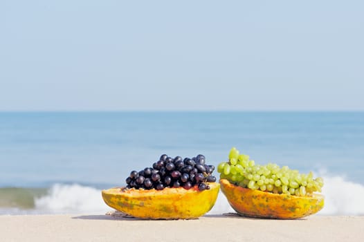 Papaya and grape on the tropical beach
